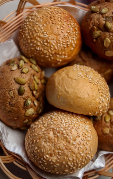 Runde Brötchen mit Kleie, Nüssen und Sesam. Brot im Korb. Frisch gebackene Vollkornbrötchen mit Hafer, Nüssen und Samen. Vollkornbrötchen. Nahaufnahmefoto. Weicher Fokus