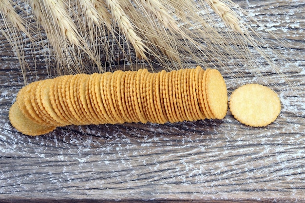 Runde Crackerkekse mit Gerstenpflanze auf Holztisch