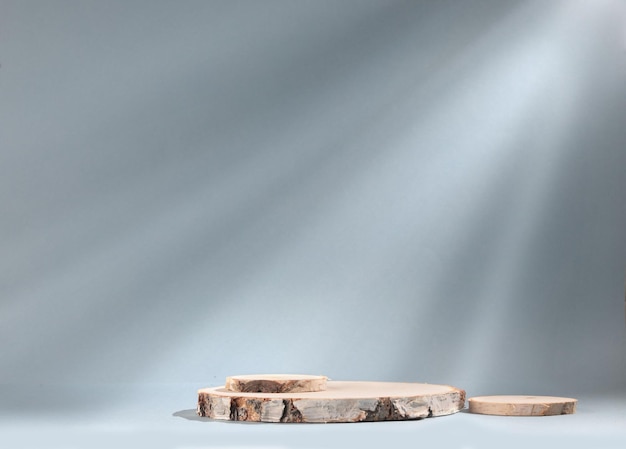 Runde Holzplatte aus zylindrischer Birkenplatte auf grauem Hintergrund mit Sonnenlicht Podium. Ein leeres