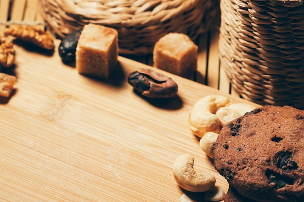 Runde knusprige Schokoladenkekse mit Nüssen, Kakaochips und Gewürzen auf Schneidebrett mit Kopierraum