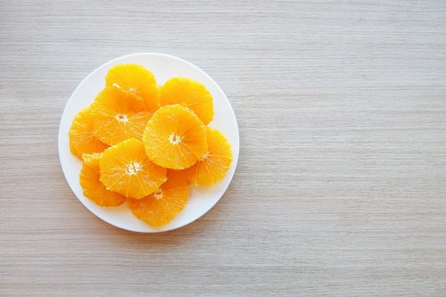 Runde Scheiben saftige Orange auf einer weißen Untertasse