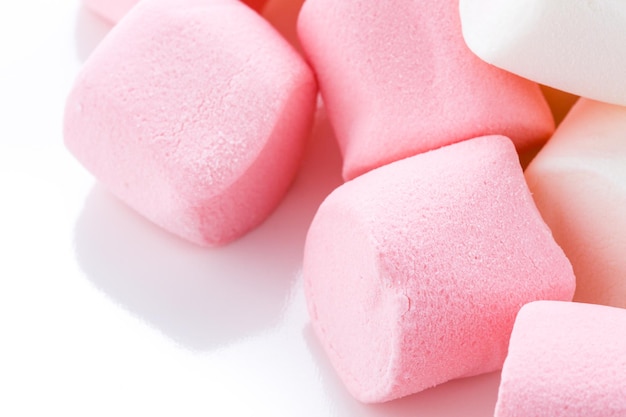 Runde weiße und rosa Marshmallows auf einem weißen Hintergrund.