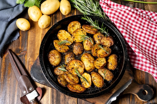 Foto runder bräter mit leckeren bratkartoffeln mit frischen und natürlichen kräutern