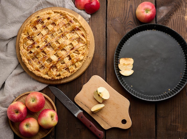 Runder gebackener Apfelkuchen auf einer braunen Holztischplatteansicht