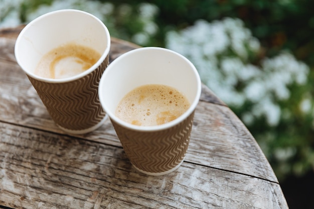 Runder Holztisch mit ein paar braunen Papiertassen frischen heißen Kaffees