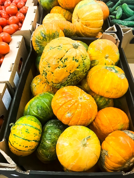 Runder orange Kürbis auf Supermarktregalen, Verkauf.