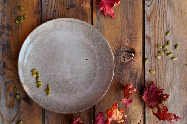 Rundes Gericht auf einem hölzernen Hintergrund mit Blättern Herbstatmosphäre