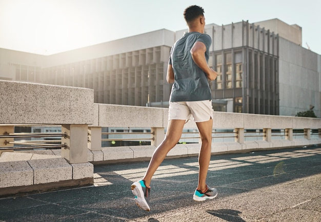 Running Fitness und City Man für Körpertraining Training und Bewegung mit Motivationsziel und Energie in der Morgensonne Junge Sportler oder Läufer laufen auf städtischen Straßen oder Brücken für die Gesundheit