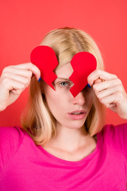 Ruptura de relaciones mujer triste con corazón de papel roto en manos amor infeliz amor concepto rojo