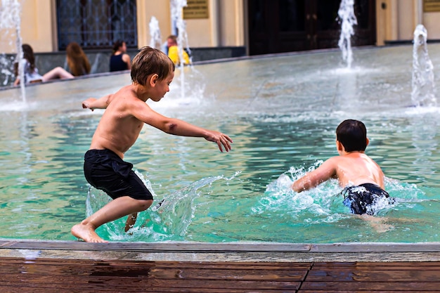 Rusia Moscú 4 de agosto de 2018 niños nadando en la fuente de la ciudad editorial