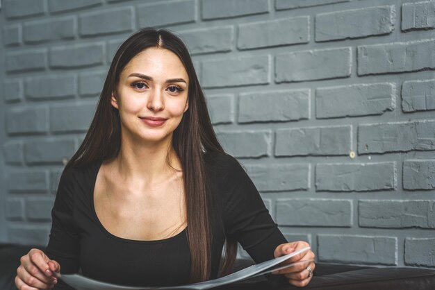 Rusia San Petersburgo 17 2020 de febrero una joven sentada en un sofá leyendo una revista de moda