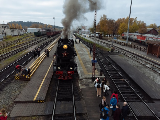 RUSKEALA RÚSSIA 09 DE OUTUBRO DE 2022 Antiga locomotiva a vapor soviética da série L com trem turístico Ruskeala Express no transporte em um dia ensolarado de outubro