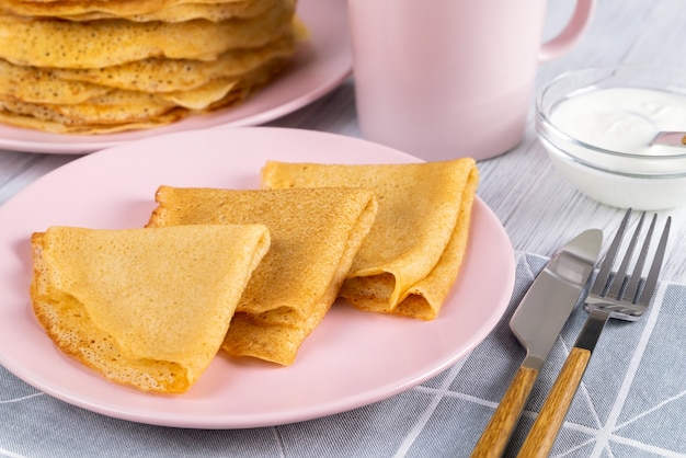 Russische Crepes oder Pfannkuchen auf einem rosa Teller