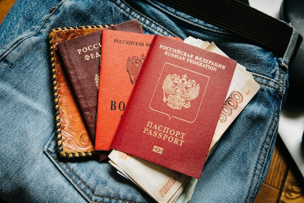 Russische Dokumente und Bargeld liegen auf einem Haufen Sachen, der Mann will gehen