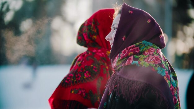 Russische Folklore eine Frau in einem hellen Schal, die draußen im Winterwald steht