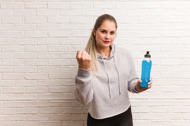 Russische frau der jungen fitness, die einen energiegetränk hält