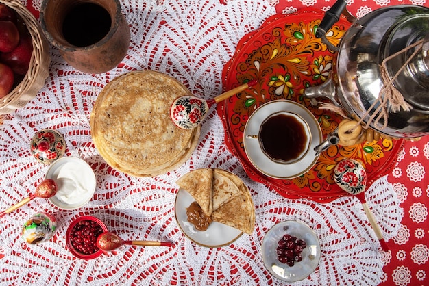 Russische Pfannkuchen-Blini mit Beeren und Sauerrahm auf dem Tisch Shrovetide Maslenitsa Festival concep