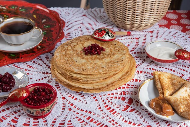 Foto russische pfannkuchen-blini mit beeren und sauerrahm auf dem tisch shrovetide maslenitsa festival concep