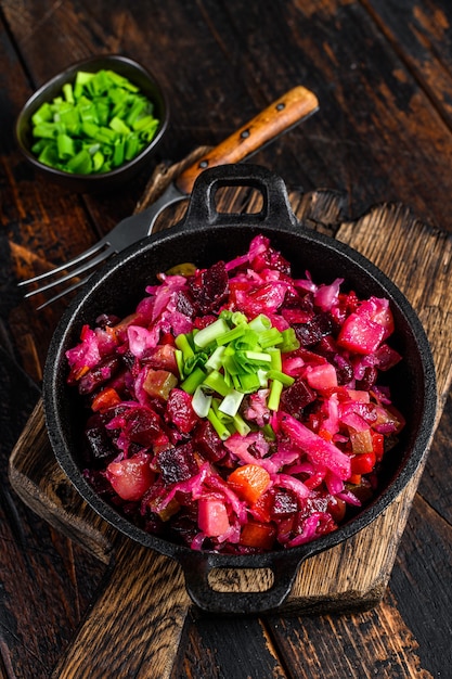 Foto russische rote-bete-gemüsesalat-vinaigrette in einer pfanne. holzhintergrund. draufsicht.