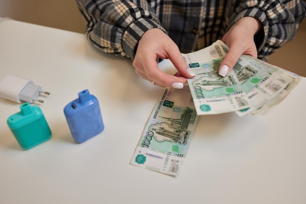 Russische Rubel in der Hand einer fanmännlichen Hand, die viele der russischen Banknoten hältDer GeldtransferDas isolierte Fünftausendstel der russischen Rubel-Bezeichnungen in einer Hand