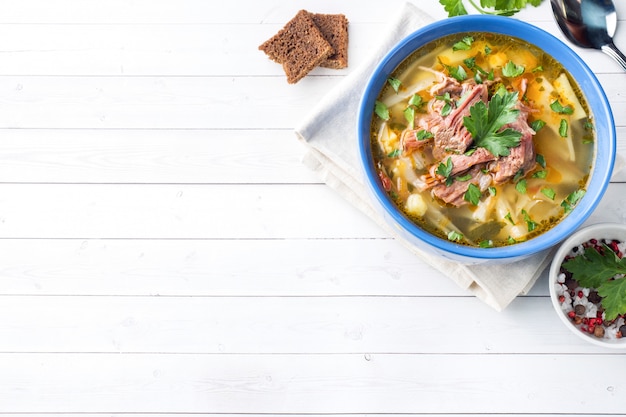 Russische traditionelle Kohlsuppe mit Fleisch und frischen Kräutern auf einem Leuchtpult.