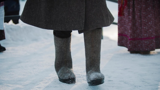 Russische Traditionen eine Person in Filzstiefeln, die im Winter tanzt