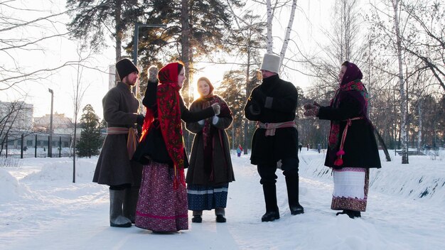 Russische Volksleute in Filzstiefeln tanzen im Winter im Freien