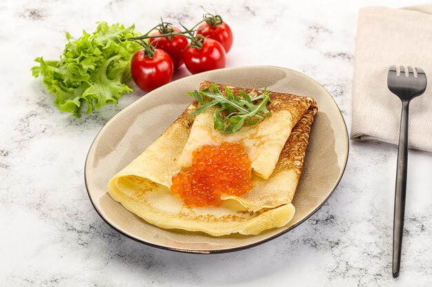 Russischer Pfannkuchen mit rotem Kaviar und Rucola