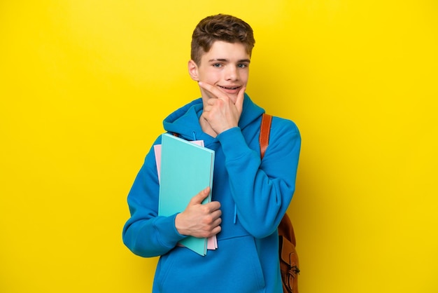 Russischer Student des Teenagers lokalisiert auf gelbem Hintergrund glücklich und lächelnd