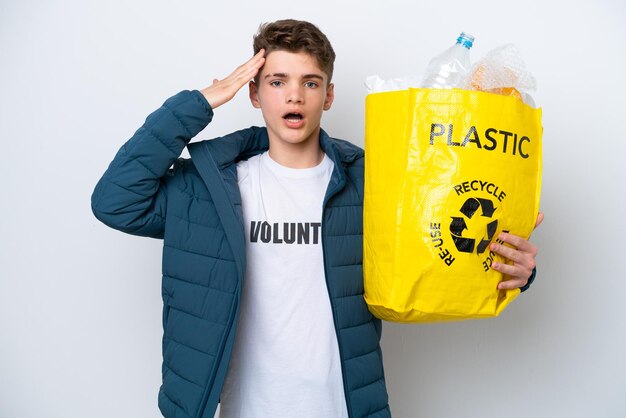 Russischer Teenager, der eine Tasche voller Plastikflaschen hält, um sie auf weißem Hintergrund mit Überraschungsausdruck zu recyceln