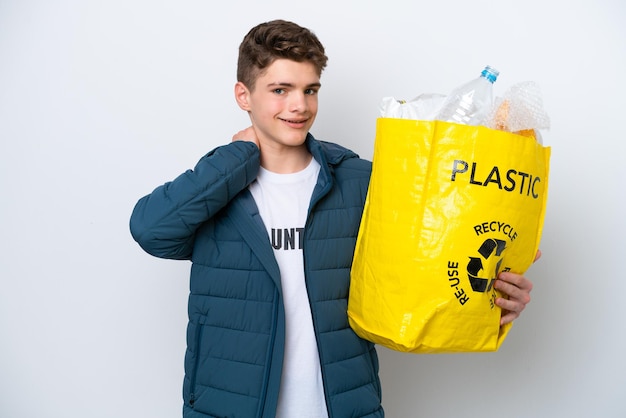 Russischer Teenager, der eine Tüte voller Plastikflaschen zum Recyceln auf weißem Hintergrund hält, lacht