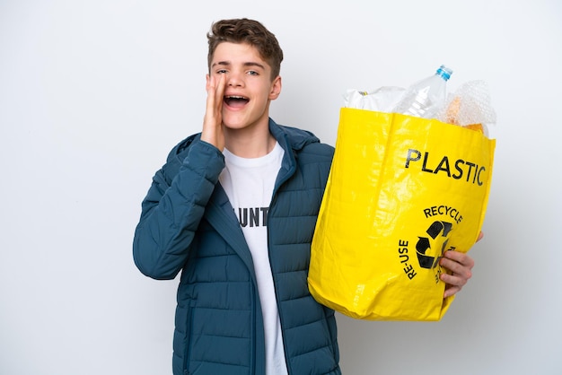 Russischer Teenager, der eine Tüte voller Plastikflaschen zum Recyceln auf weißem Hintergrund hält und mit weit geöffnetem Mund schreit