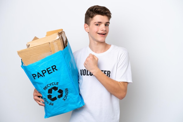 Russischer Teenager, der einen Recycling-Beutel voller Papier hält, um isoliert auf weißem Hintergrund zu recyceln und einen Sieg zu feiern