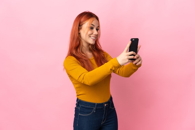 Russisches Mädchen des Teenagers isoliert, das ein selfie macht