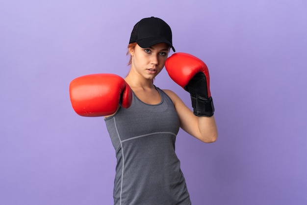 Russisches Mädchen des Teenagers lokalisiert auf lila Wand mit Boxhandschuhen