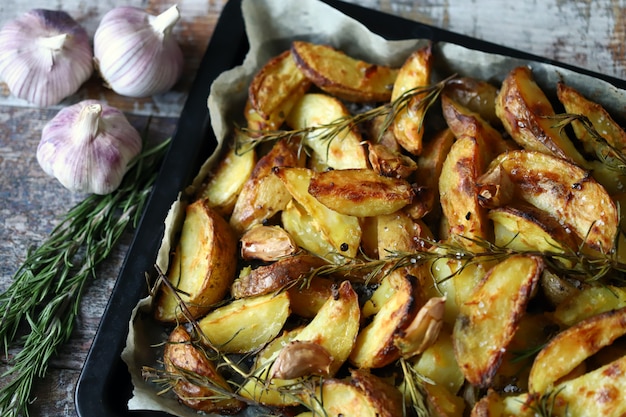 Rústico dorado papa al horno. Rodajas de papa al horno con especias, ajo y romero.