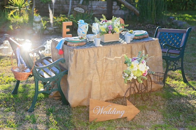 Rustikal dekorierter Hochzeitstisch im Feld bei Sonnenuntergang