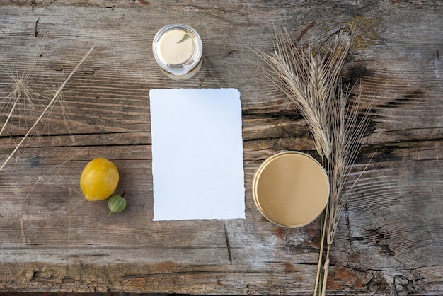 Rustikale Hochzeitskarte Mockup Weißes Papierblatt auf Holzhintergrund, flach, Ansicht von oben Gestylter Bestand