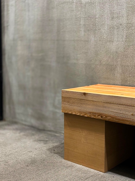 Rustikale Holzbank an einer Betonmauer