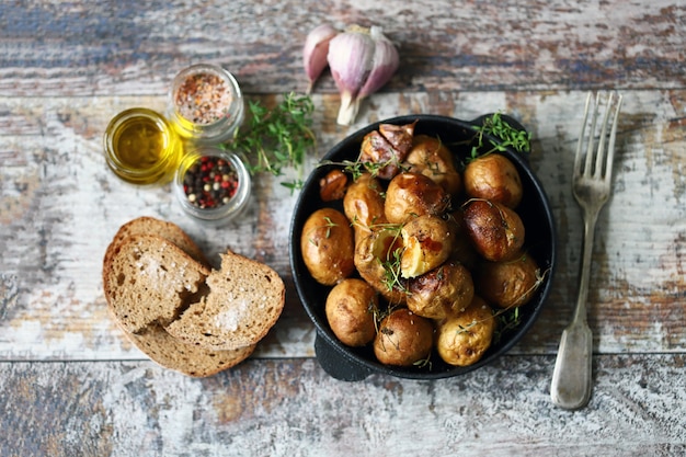 Rustikale Kartoffel in einer Pfanne. Gebackene kleine Kartoffeln in einer Schale mit Knoblauch und Kräutern. Selektiver Fokus.