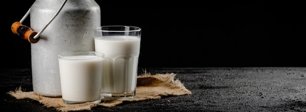 Foto rustikale milch in einer dose und ein glas auf dem tisch