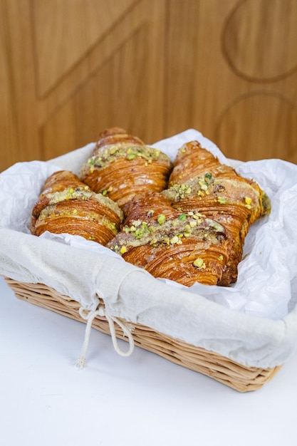 Foto rustikaler korb mit croissants auf weißem tisch