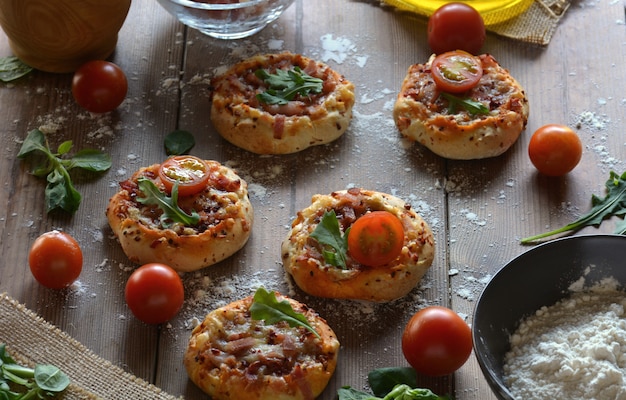 Rustikaler Tisch mit Mini-Pizza Speck