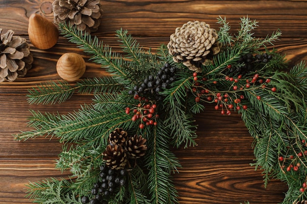 Rustikaler Weihnachtskranz auf Holztisch flach lag Frohe Weihnachten