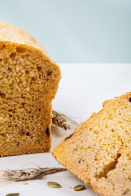 Rustikales Brot der Weizenhefe mit Kürbiskernen auf weißer Holzbrettoberfläche Studiofoto