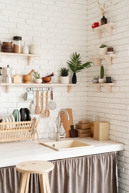 Rustikales Kücheninterieur mit weißer Backsteinmauer und weißen Holzregalen