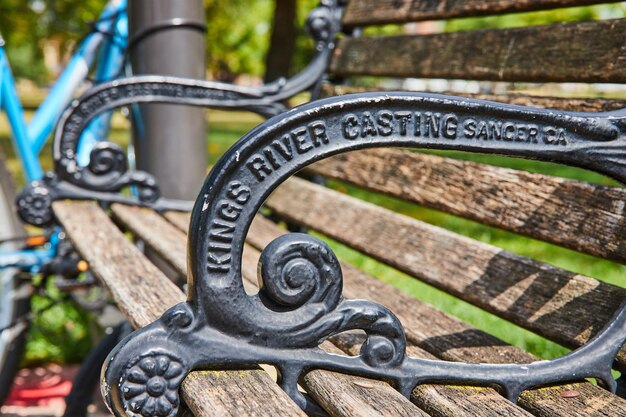 Foto rustikales parkbankdetail mit fahrrad und grünen hintergrund