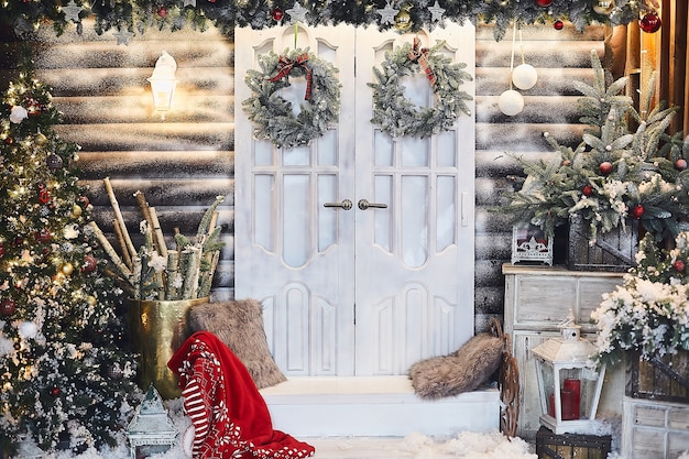 Rustikales Winterinterieur für Neujahr mit Kunstschnee und Weihnachtsbaum. Winteraußenseite eines Landhauses mit Weihnachtsdekorationen im rustikalen Stil.