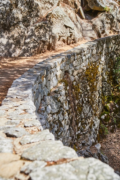 Ruta de senderismo con un muro de piedra gigante a lo largo de los acantilados