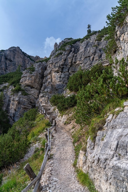 Ruta de senderismo con una valla de madera en los Dolomitas italianos Rocas cielo azul